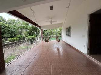 Open concept living room with tile floors and large windows Playa Corona beach house Panama
