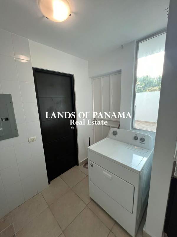 L-shaped kitchen with granite countertops, built-in stove and wooden cabinets at PH Clayton Park I Panama