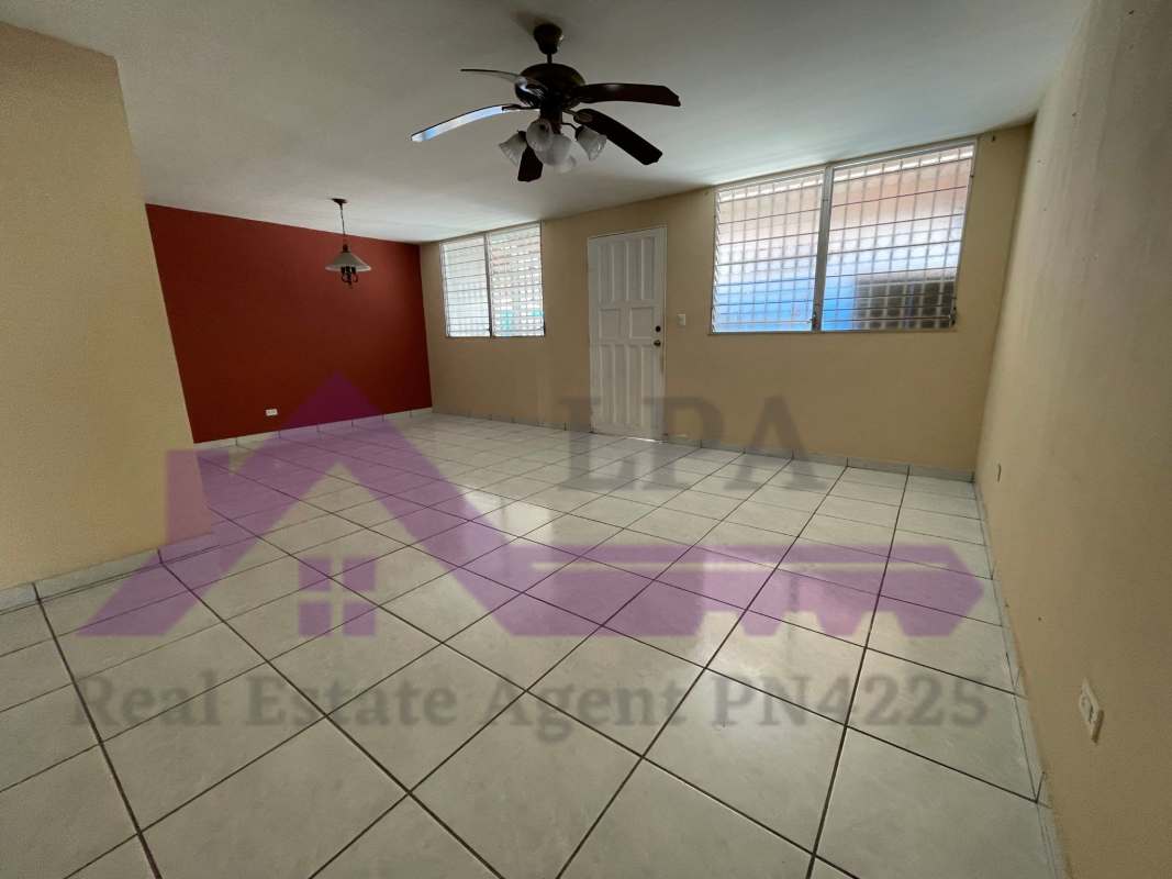 Large living dining room area with tiled floors and ceiling fan in duplex house Panama