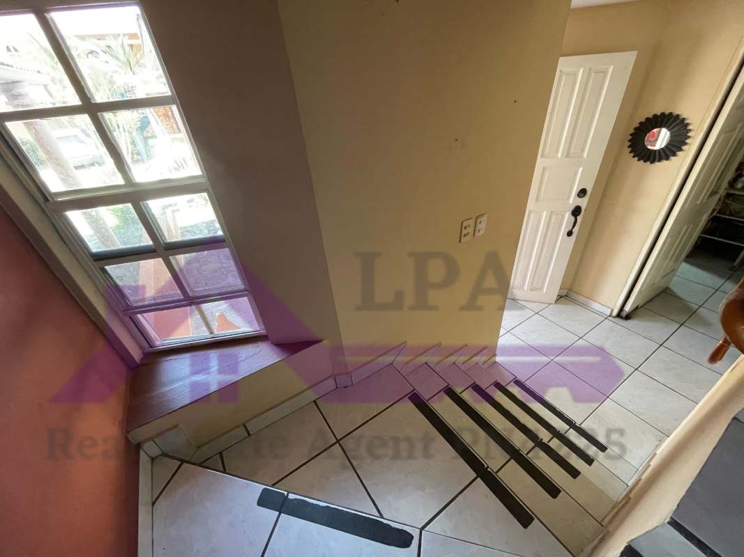 Additional living room or den with accent wall and tile floor in duplex house Panama