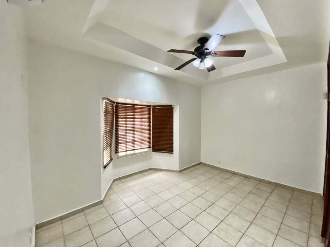 Empty bedroom with tiled floor, tray ceiling, ceiling fan, AC, windows Albrook Panama house