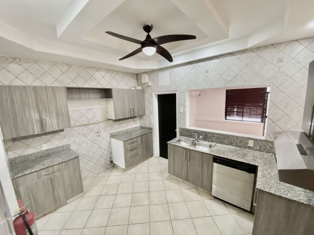 Kitchen with granite countertops, grey cabinets, double sink, tiled walls, Albrook house Panama