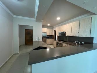 Kitchen in Bijao condo opens to living area with granite counters, appliances Panama