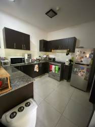 Modern kitchen with granite countertops, dark cabinetry, stainless appliances in Woodland duplex