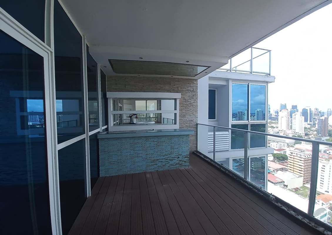 Balcony with outdoor bar counter, glass railings, Panama City skyline at PH Quadrat apartment