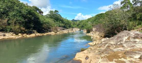 Scenic river flowing through lush forest landscape bordering the rural lot in Coclé