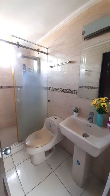 Modern bathroom with pedestal sink, glass shower, and accent tiles PH Monterrey La Loma Panama