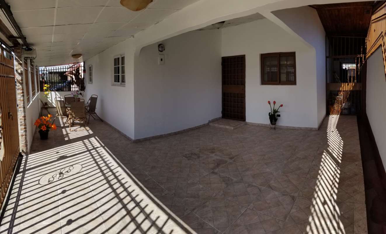 Covered terrace with seating, tile floor, security entrance gate in Chanis Pedregal Panama house