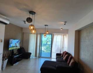 Modern living room with sectional sofa, TV, large glass doors to oceanfront balcony at Royal Palm Nueva Gorgona