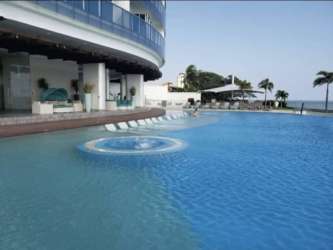 Ocean view infinity pool with lounge chairs at Royal Palm condominium Malibu Beach
