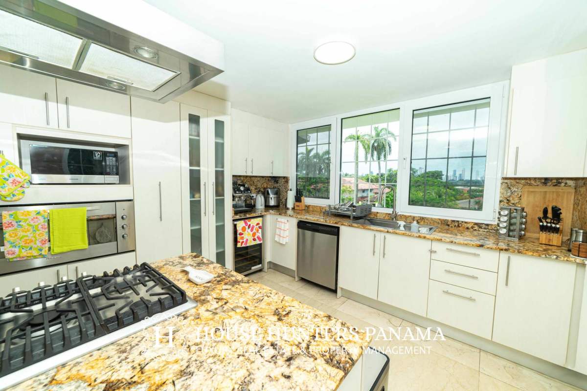 Elegant gourmet kitchen with granite counters, stainless steel appliances and large windows in Albrook luxury house