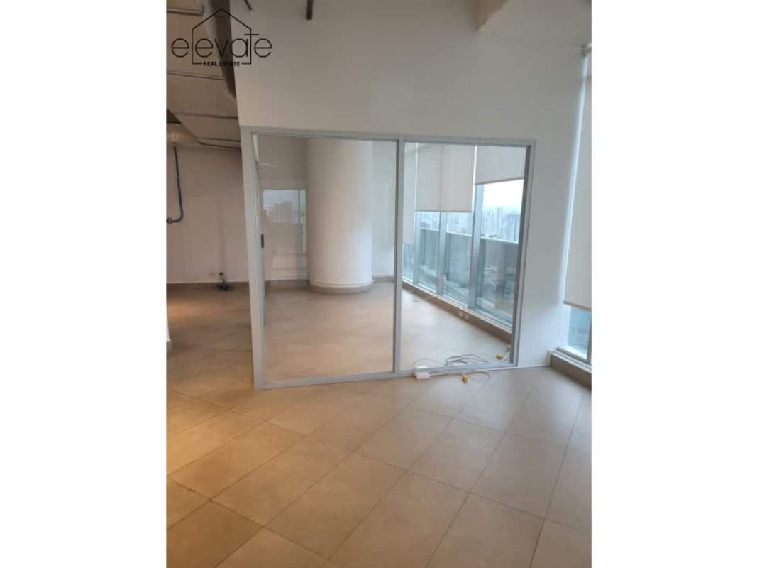 Contemporary office with exposed ceiling ducts, terrace access, and large windows at F&F Tower Panama