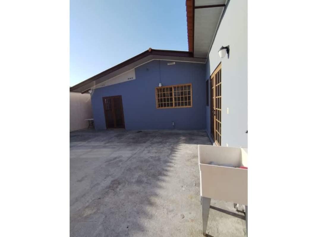 Blue facade one level house, patio courtyard, wooden window frames in Brisas del Golf Panama City