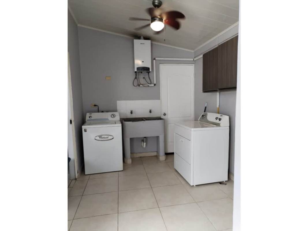 Laundry room with washer dryer, water heater, utility sink Brisas del Golf home