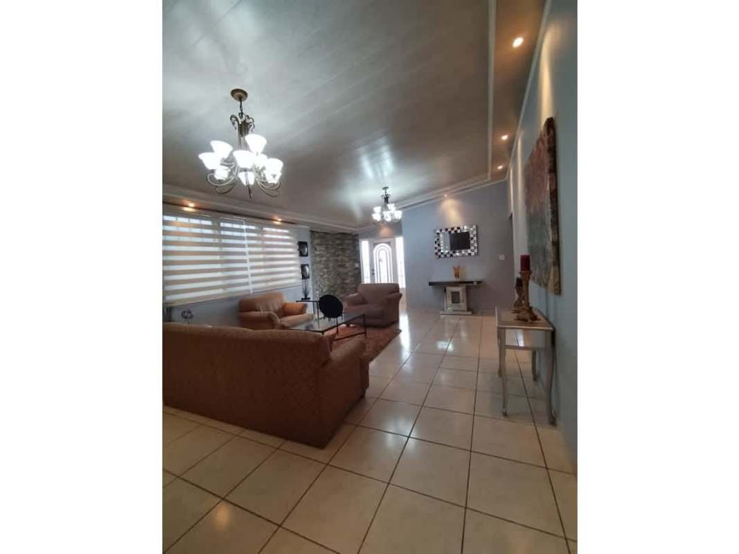 Open plan living dining space with chandeliers, tile flooring at Brisas del Golf house for sale in Panama