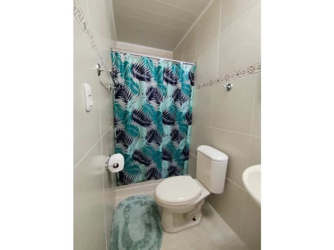 Full bathroom with ceramic tiles, tropical shower curtain and vanity in family house for sale in Brisas del Golf