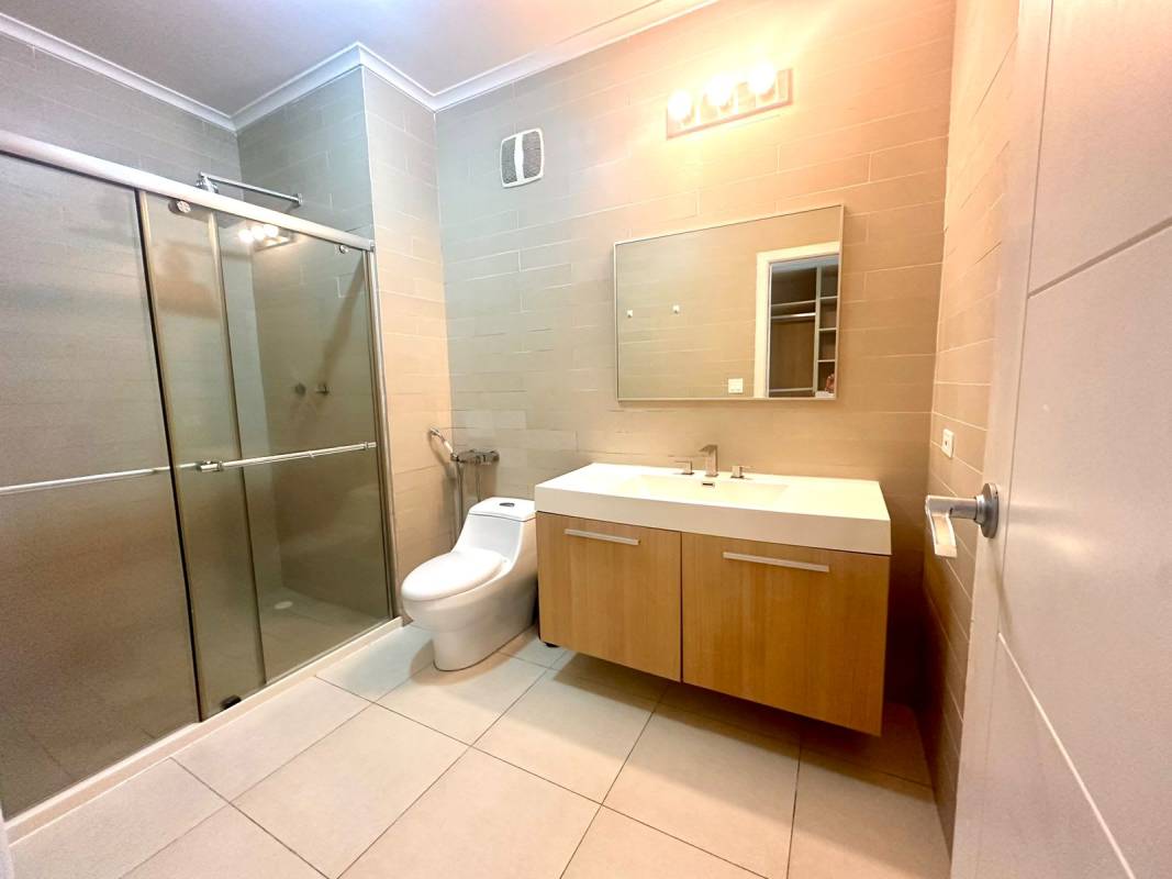 Bathroom with glass shower enclosure, modern vanity at PH White Tower Panama City