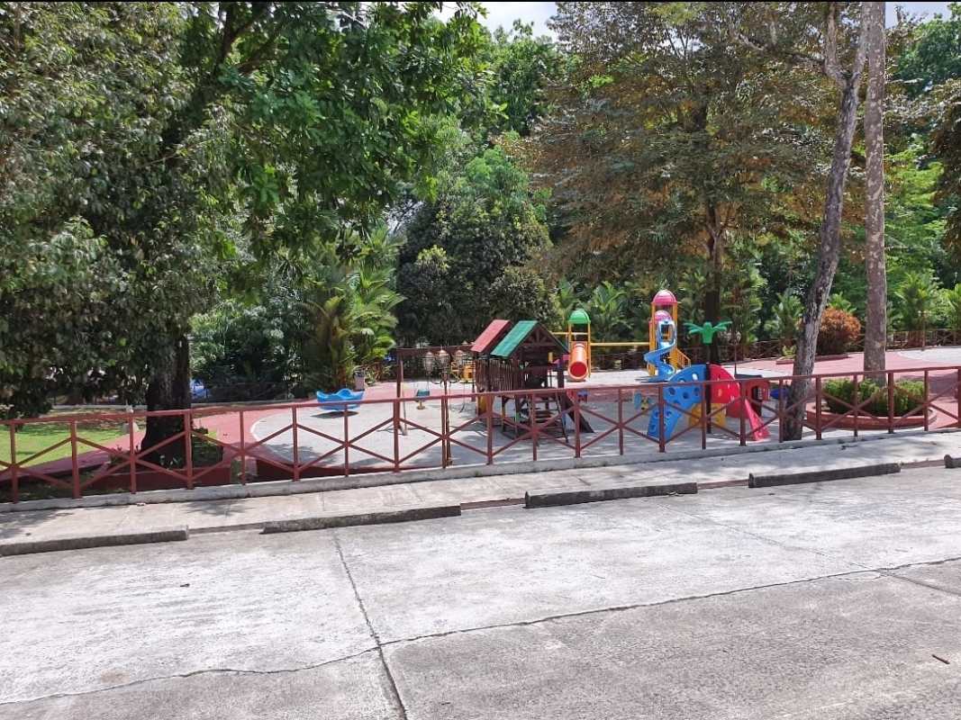 Colorful children’s playground with slide swing amid fenced green park in Camino de Cruces gated community Panama