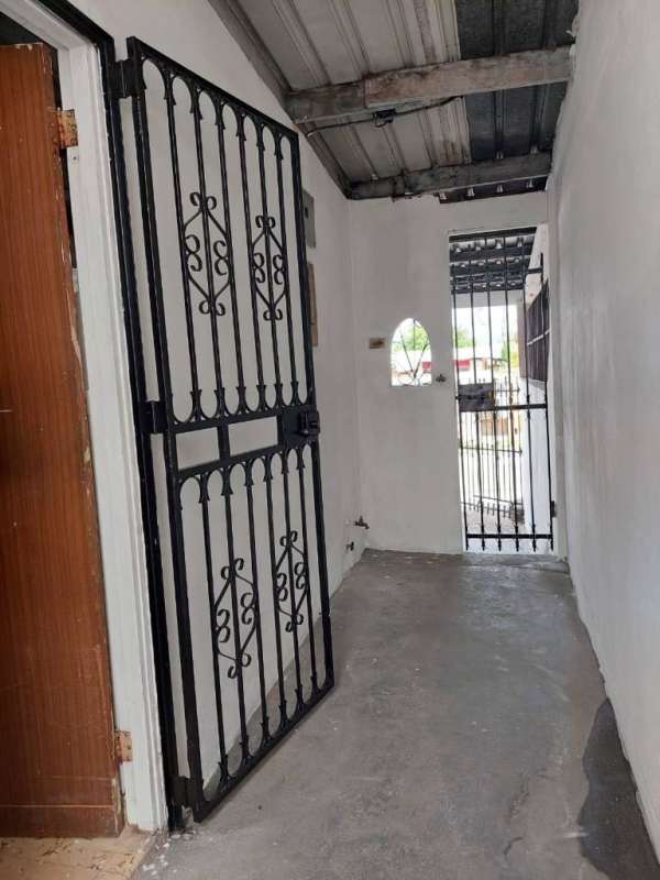 Interior entryway with barred gate and concrete floor family home Juan Díaz Panama