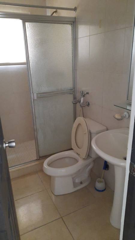 Modern bathroom with glass shower enclosure tile walls vanity and toilet PH Villa de las Fuentes Panama