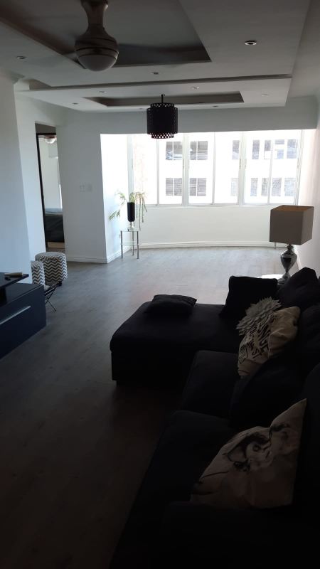 Open living dining room with large window, recessed ceiling and modern tile floors at PH Villa de las Fuentes Panama City