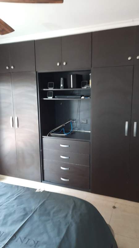 Bedroom with built-in wardrobes and shelving dark wood at PH Villa de las Fuentes Panama City