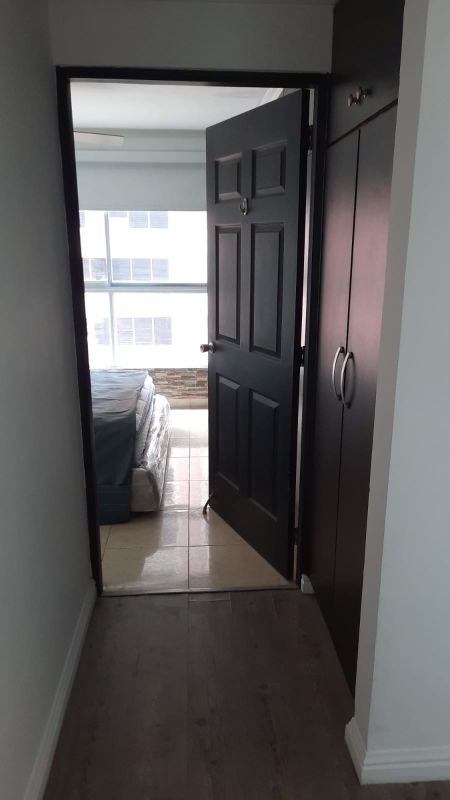 Bedroom with city view through large window built-in wardrobe PH Villa de las Fuentes Panama