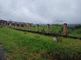 Open grassy lot with partial fencing overlooking mountain landscape Boquete Chiriquí Panama