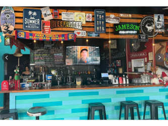 Outdoor seating area with string lights, covered dining and greenery at Sandbar Gastropub in Coronado Panama