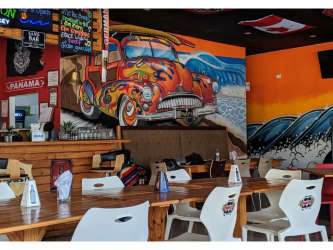 Nighttime exterior with neon signage patio seating Sandbar Gastropub Punta Barco Coronado