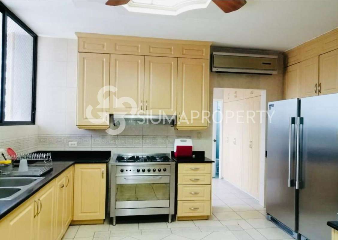 Traditional kitchen beige cabinetry, black countertops, stainless appliances PH Golden Palace Punta Paitilla