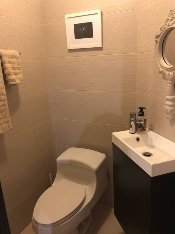 Compact half bath guest powder room with contemporary fixtures, beige tiles in Destiny Tower Panama City
