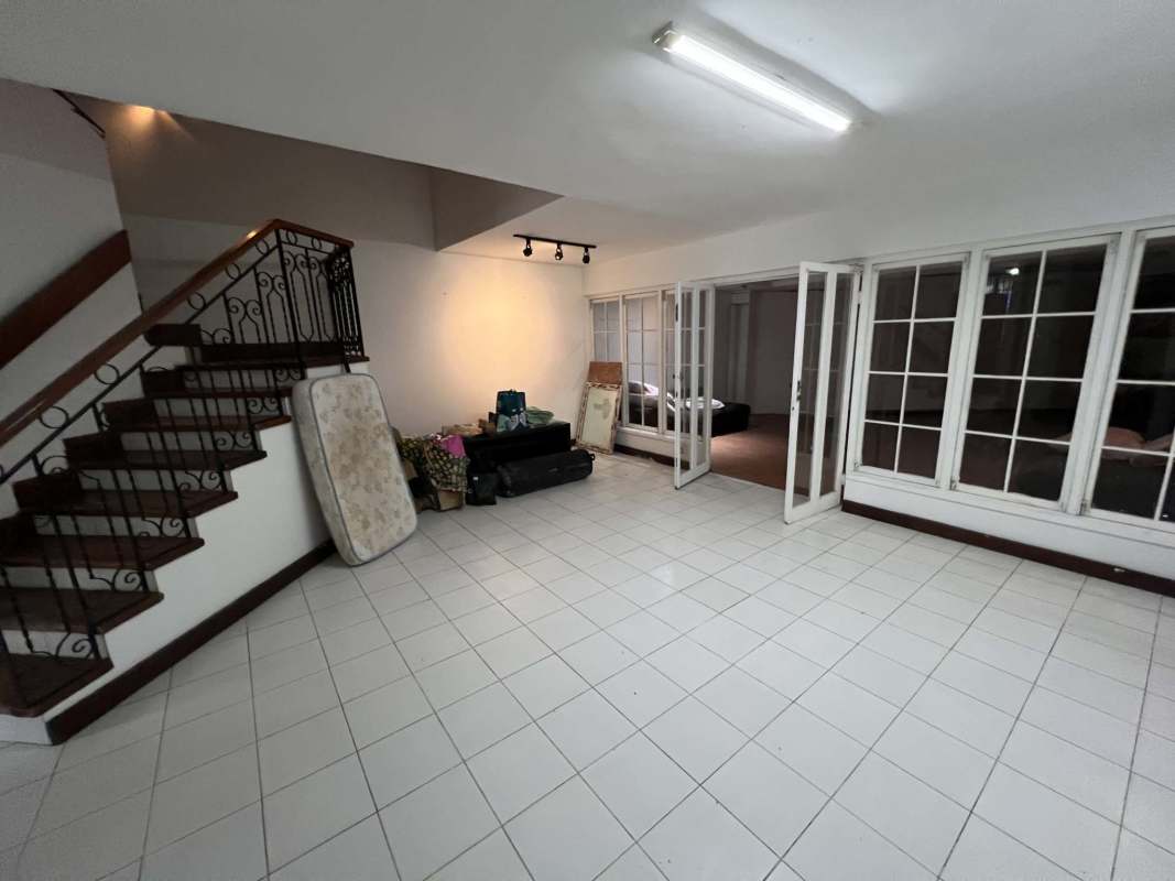 Large living area with tile floor, iron staircase in Obarrio Panama house
