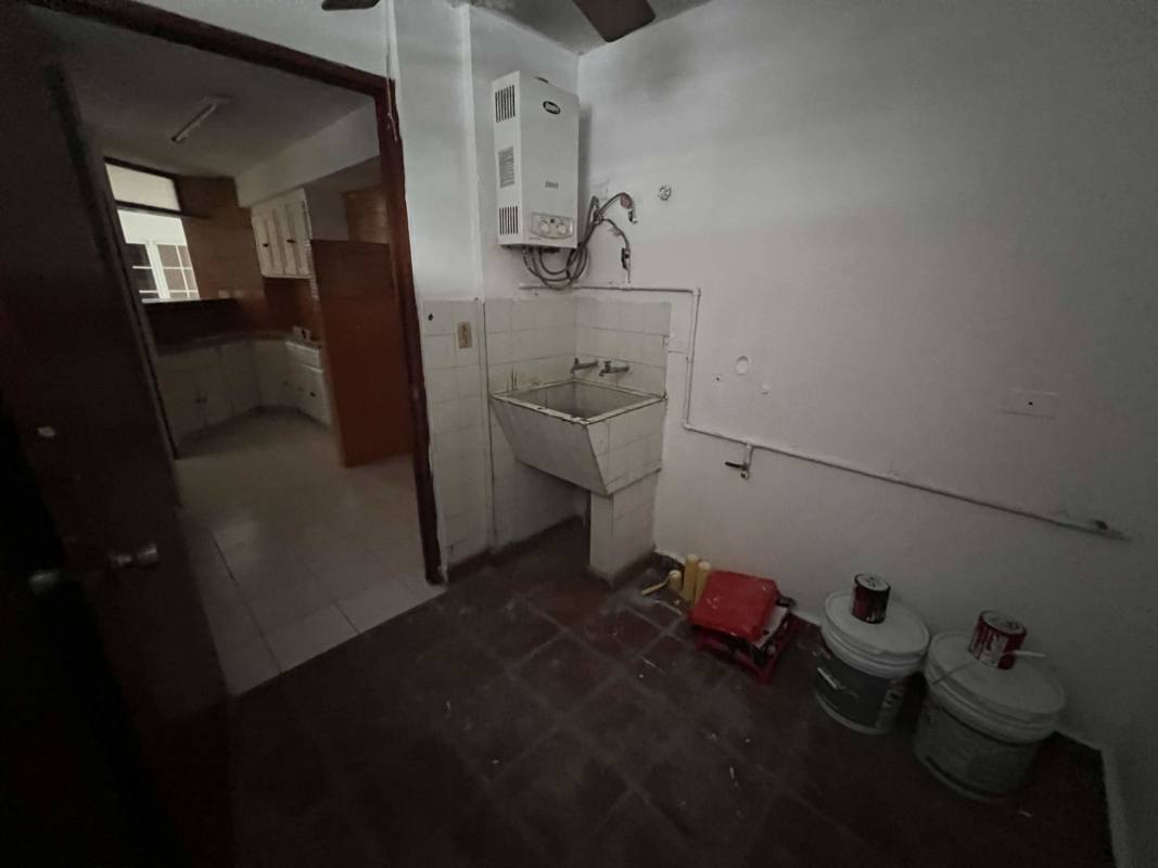 Kitchen with wood cabinets, tile countertop in house for sale Obarrio Panama