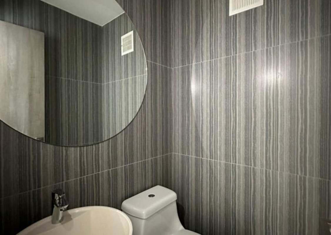 Minimalist bathroom with striped tiles, white fixtures at PH Velure Panama