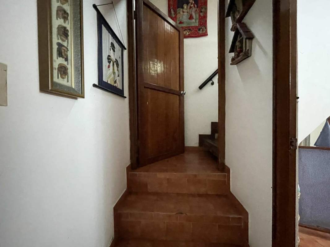 Large bedroom with panoramic window and rustic design overlooking greenery in Cerro Azul