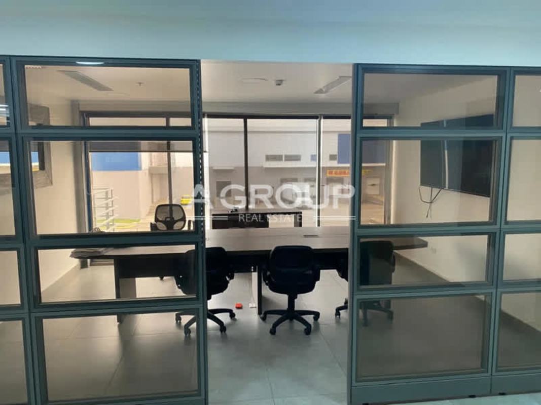 Glass enclosed meeting room with office table and chairs in warehouse office Panama