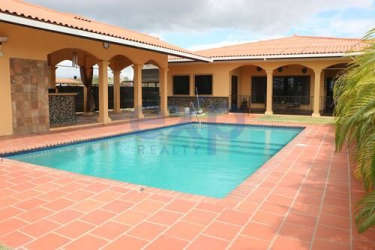 Open concept living area with large windows, natural light and view of pool and gardens in luxury home Nueva Gorgona Panama