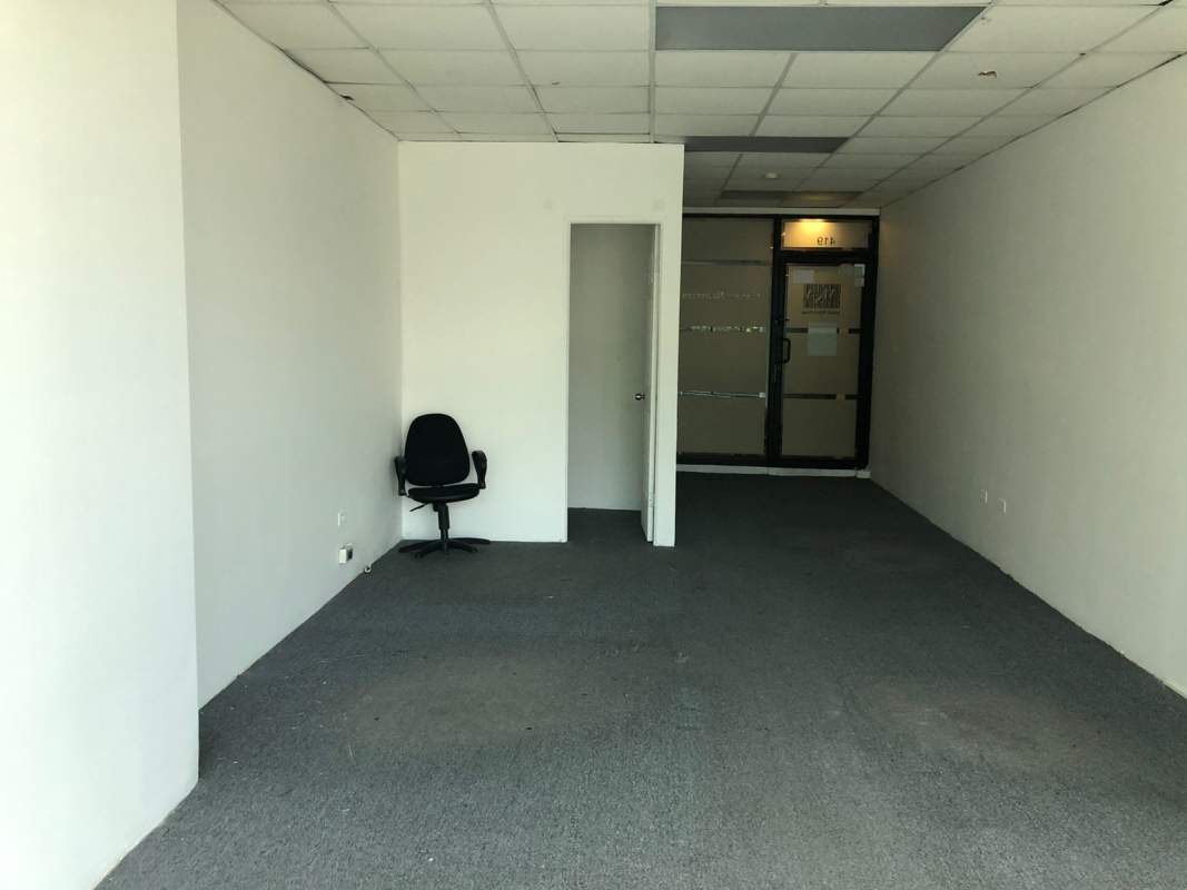 Open office area with carpet flooring, drop ceiling and glass partition at Century Tower Panama City