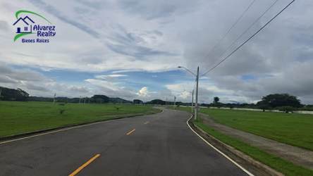 View of paved street and open green fields surrounding community in Volcán David Panama