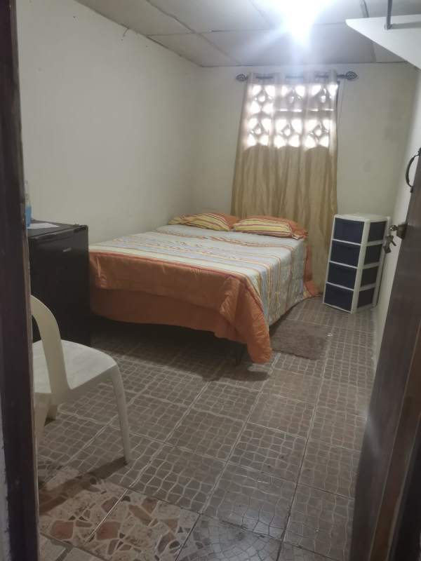 Bedroom with tiled floor, bed and fridge ideal budget rental Pedregal Panama City