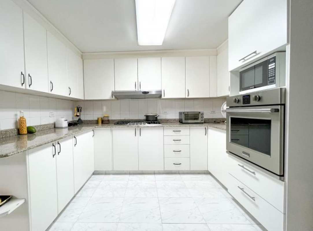Modern spacious kitchen white cabinets granite counters Obarrio Panama apartment