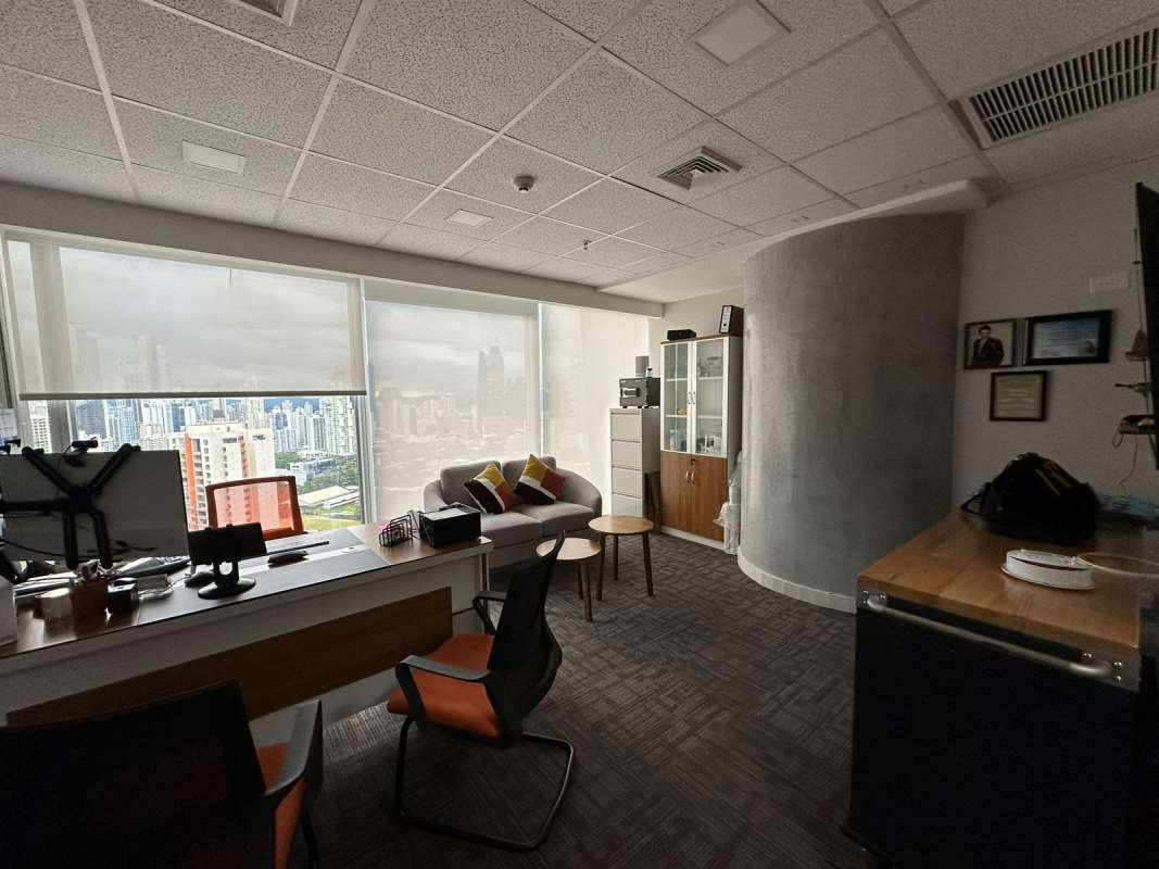 Executive office with sofa, large windows, panoramic city view in Torre Oceanía Panama