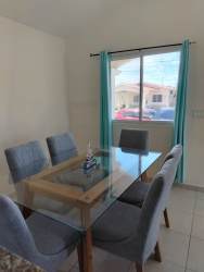 Dining room with glass table and light tile floor in Bosque Dorado PH Álamos house for sale Chorrera Panama