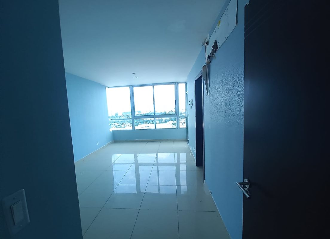 Empty living room with large windows, blue accent wall, high ceiling in PH Top Tower Costa del Este Panama