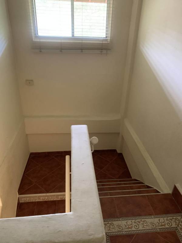 Two-story yellow house lush garden palm trees air conditioning units clayton panama rental home