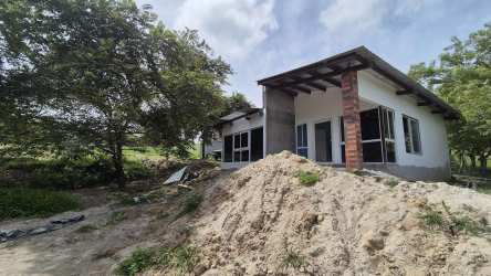 Single-family home exterior with glass sliding doors and unfinished walls in countryside Panama