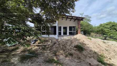 Rustic single-family home construction with large windows, wood beam roof, tropical garden in El Higo Panama