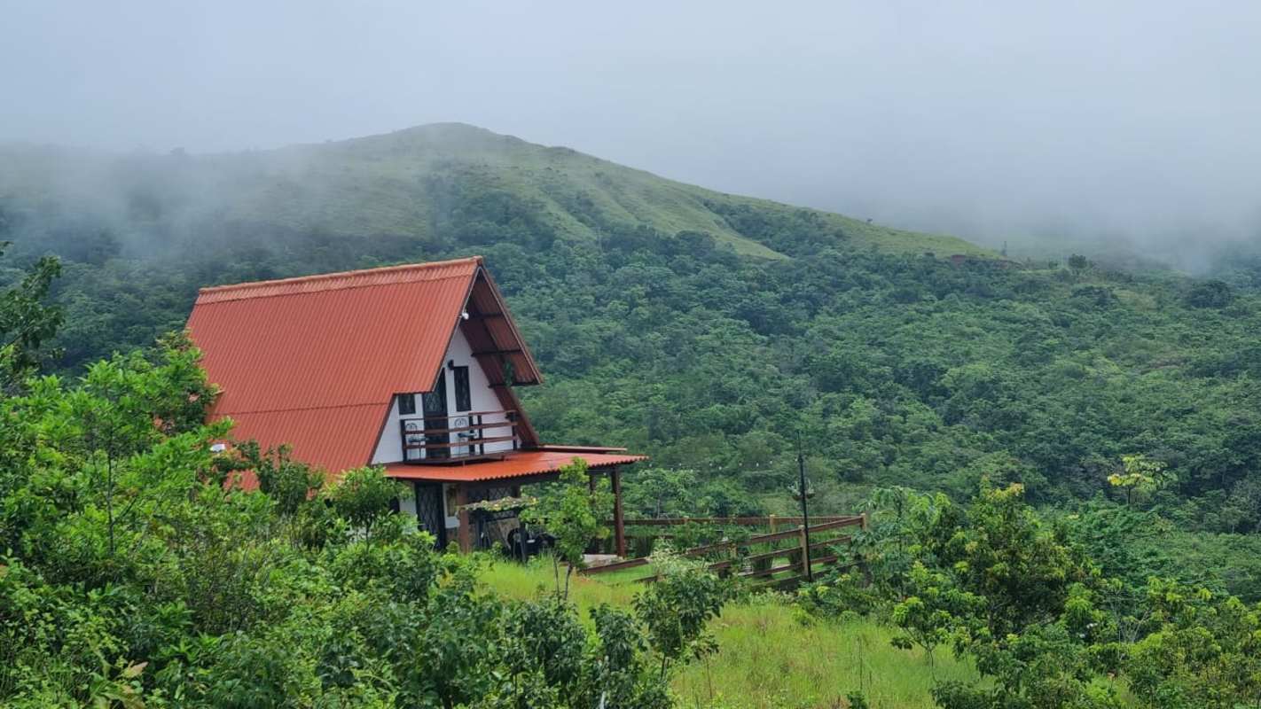 Red roof rustic cabin in misty mountain forest La Laguna San Carlos