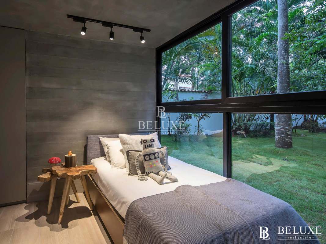 Modern bedroom with large window, gray accent wall and garden view at PH Doble Cincuentenario Coco del Mar Panama